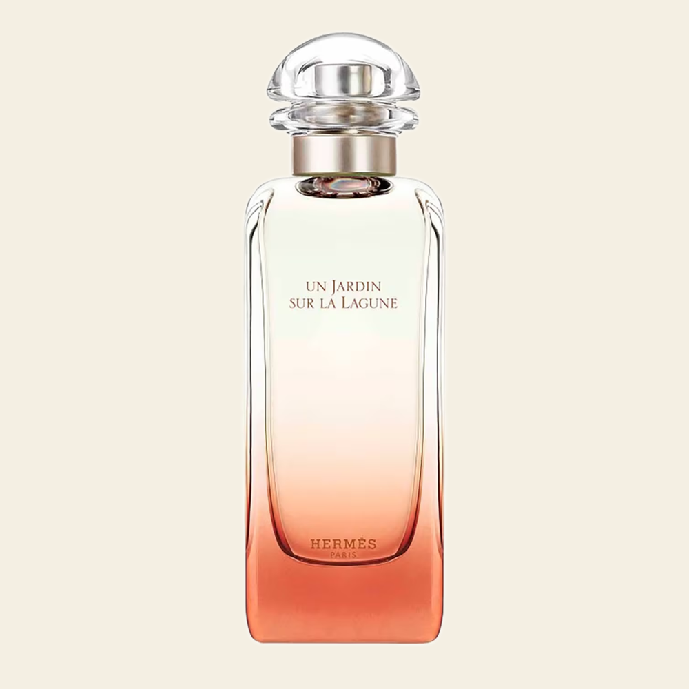 Flacon de parfum Un Jardin Sur La Lagune par Hermès sur fond ivoire