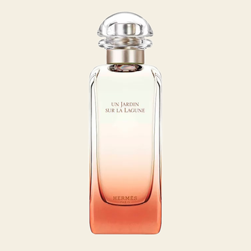 Flacon de parfum Un Jardin Sur La Lagune par Hermès sur fond ivoire